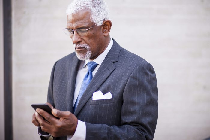 Portrait of an attractive senior business man using his phone