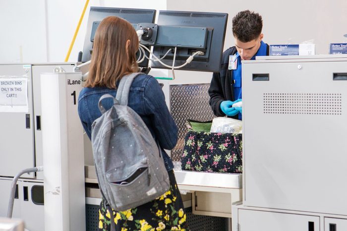 woman watching as a tsa agent searches her bag