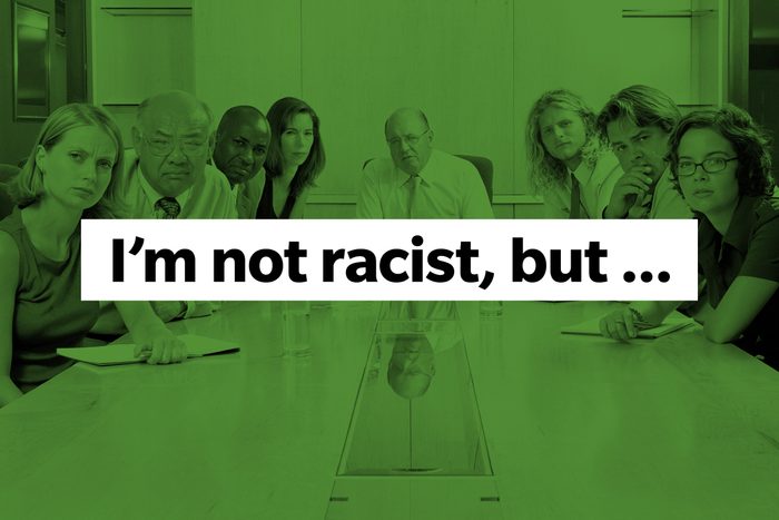 Boardroom of annoyed and upset looking people Phrase: I'm not racist but...