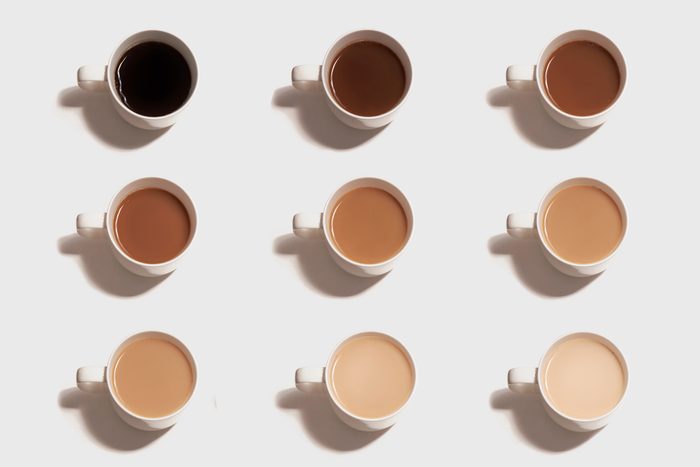 a flat lay of a grid of nine different shades of coffee in white mugs