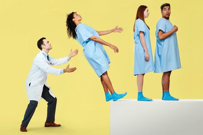 patients in line to trust fall into doctor's arms on yellow background