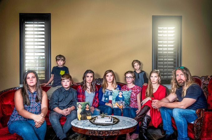 The Cogburn family on the couch holding pillows with images of sabika