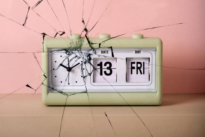 vintage clock with date that reads Fri 13. broken glass texture overlay
