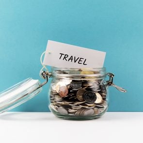 Travel Coin Jar On Blue Colored Background