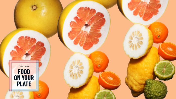 various citrus fruits on orange background