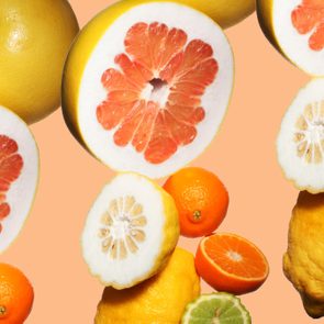 various citrus fruits on orange background