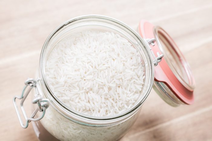 High Angle View Of An Open Jar Of Rice On Wooden Table
