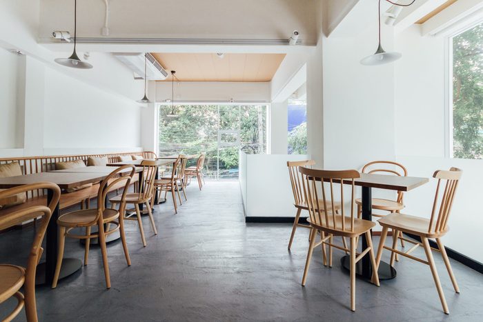 Minimal bread cafe decorating with white wall and wooden chairs. Warm, cozy and comfortable.