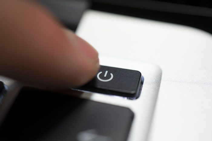 human hand press shutdown button on computer keyboard