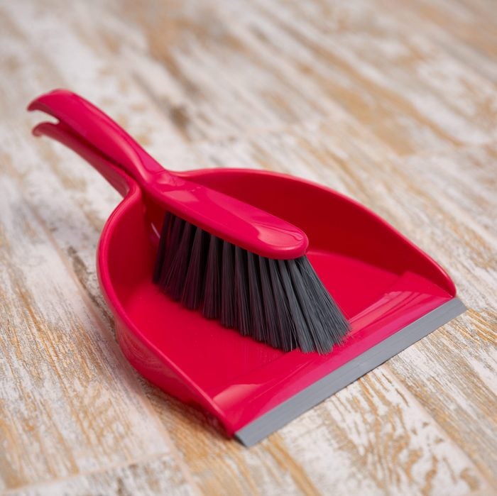 Broom and scoop on wooden background. Plastic equipment for cleaning