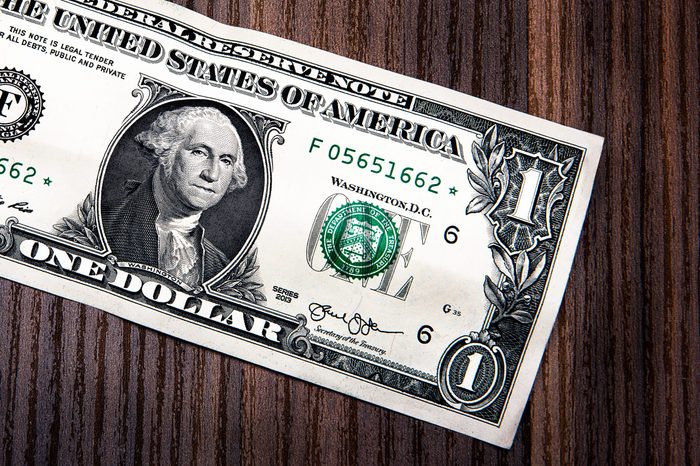 dollar bill on wooden desk close up