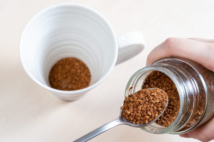 spoon near glass jar with instant coffee over mug