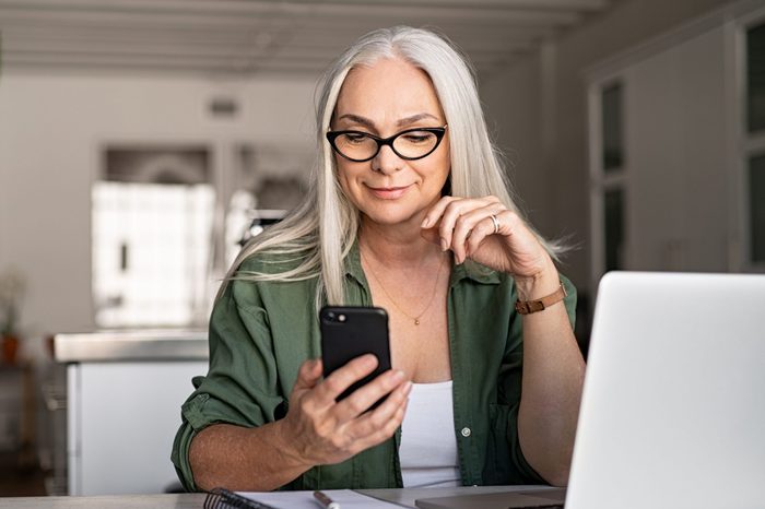 Stylish senior woman messaging with phone