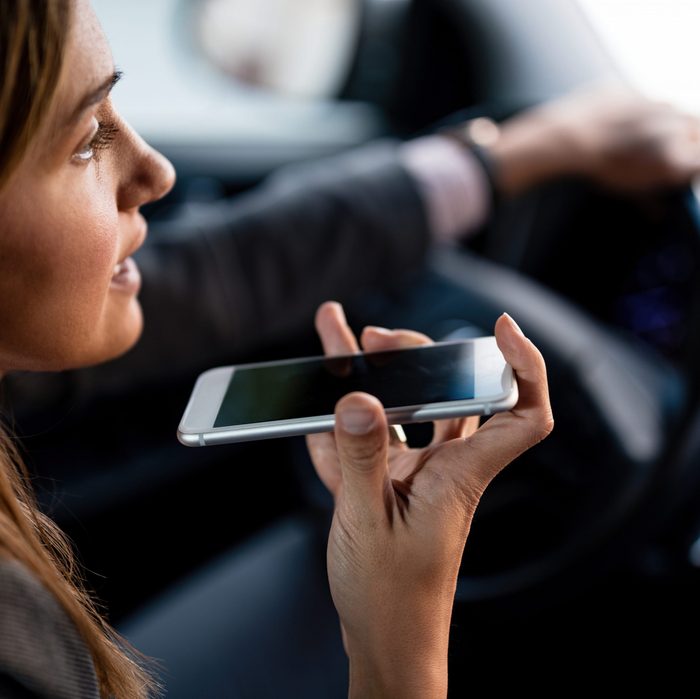 Close-up of woman talking on mobile phone while driving a car.