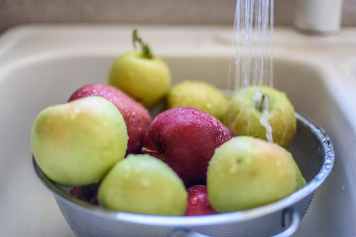Rinsing fresh apples in the sink