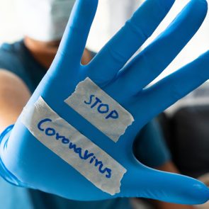 stop coronavirus written on a glove