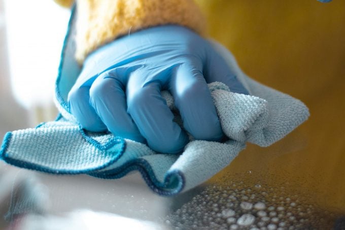 Cleaning with spray detergent, rubber gloves and dish cloth