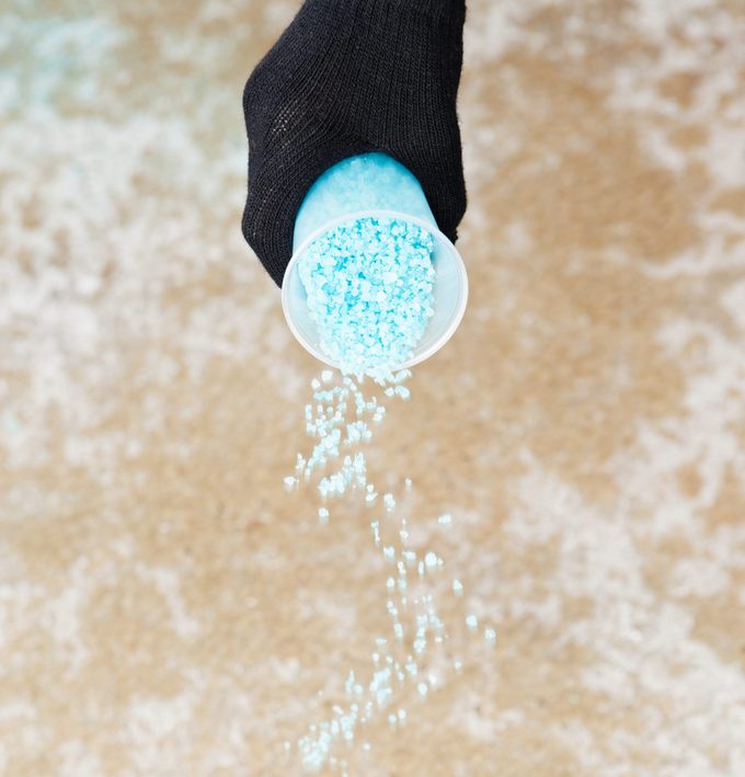 Spreading Salt on a Icy Winter Sidewalk