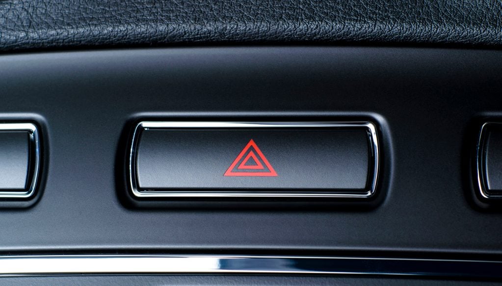 Vehicle, car hazard warning flashers button with visible red triangle.