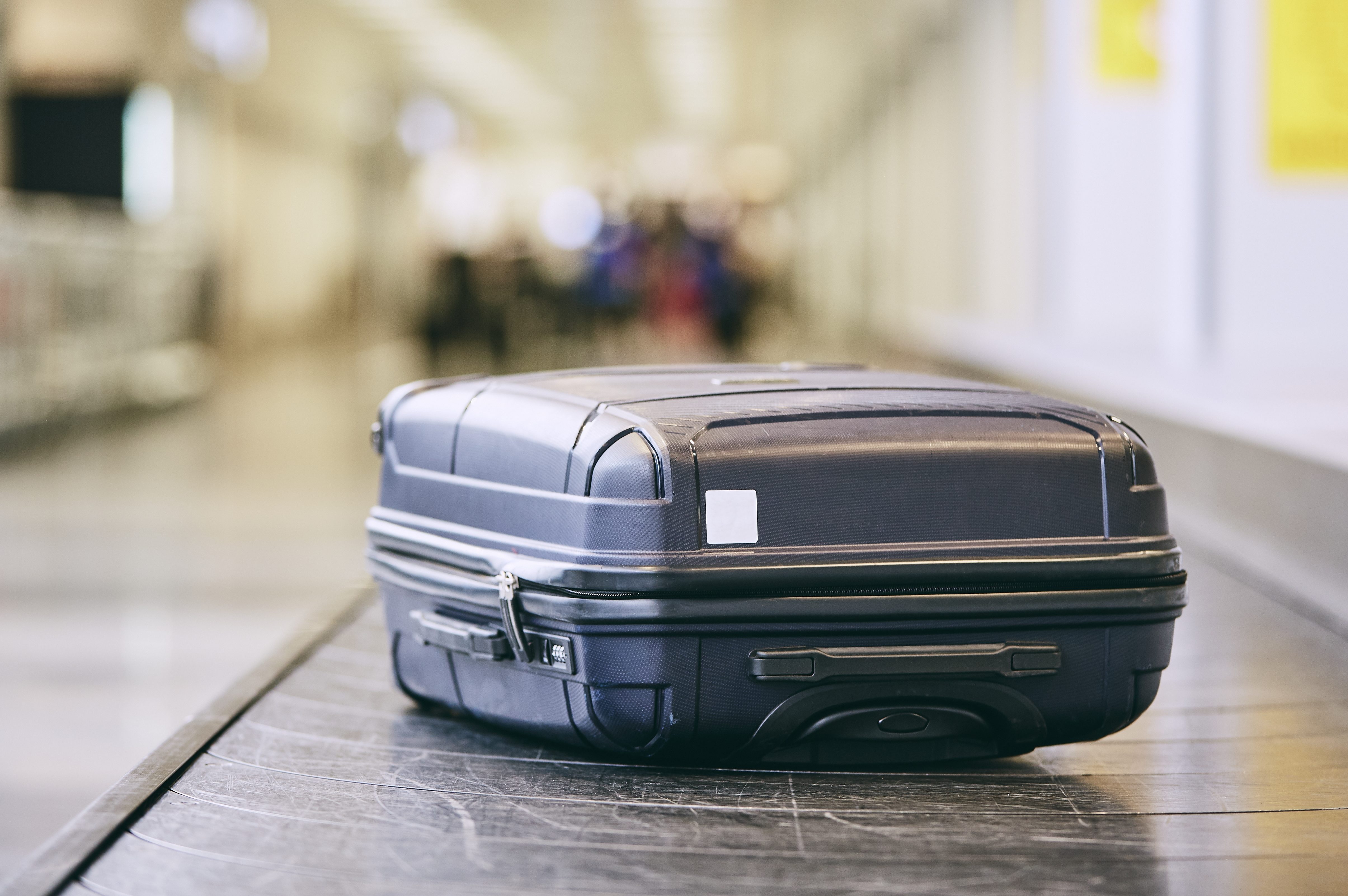 Close-Up Of Black Suitcase On Conveyor Belt At Airport