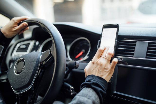 Woman using phone while driving a car