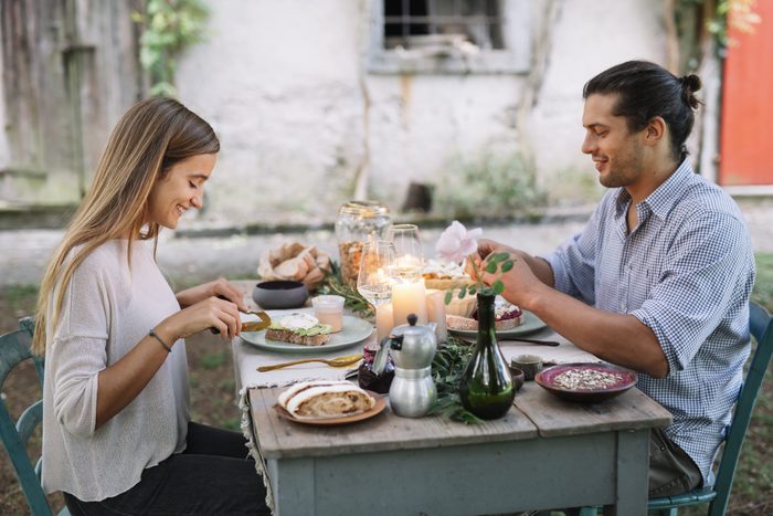 Couple having a romantic candelight meal next to a cottage