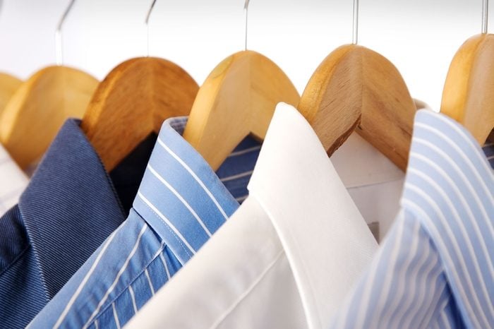 dry cleaned shirts on wooden hangers