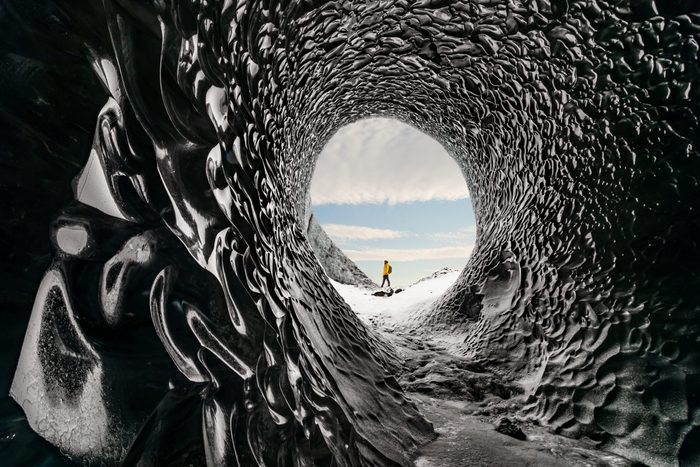 Man exploring an amazing glacial cave in Iceland