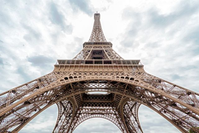 Low Angle View Of Eiffel Tower Against Cloudy Sky