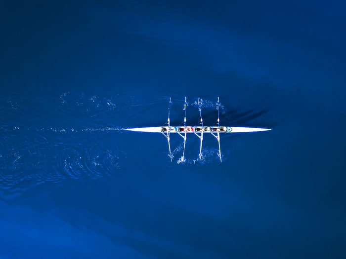 Aerial view of a rowing boat surrounded by classic blue water