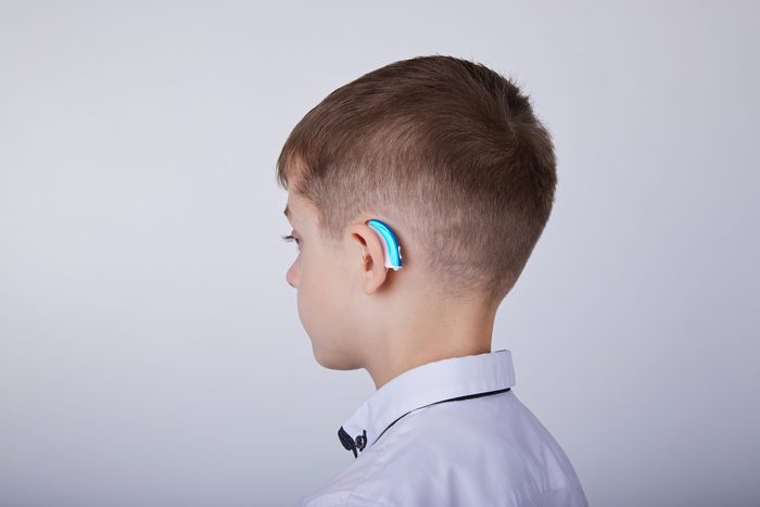 Young boy wearing a hearing aid.