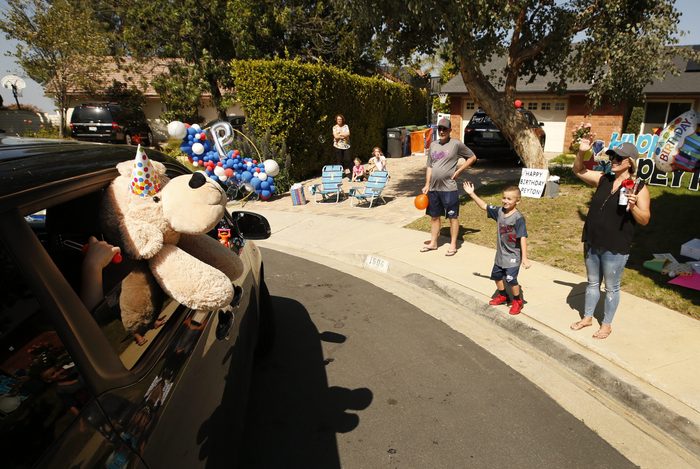 Peyton Buss waits for cars full of fellow team members from his 2019 Conejo Valley Little League All Star Baseball Team to drive by his home in Thousand Oaks to celebrate his 8th birthday amid the coronavirus Covid-19 pandemic.