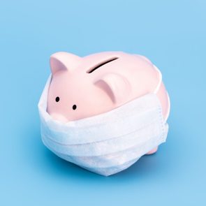 Pink piggy Bank stands in the center on a blue medical background in a medical mask. Chinese Coronavirus, 2019-nCoV