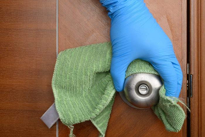 wiping a door lock with disinfectant liquid