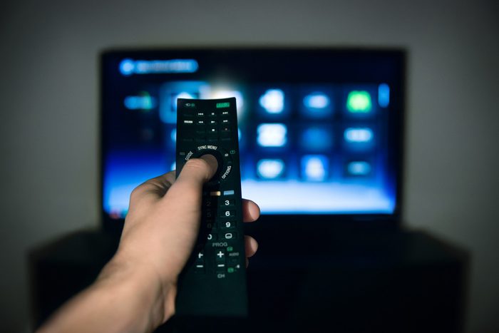 Male hand using Tv remote control
