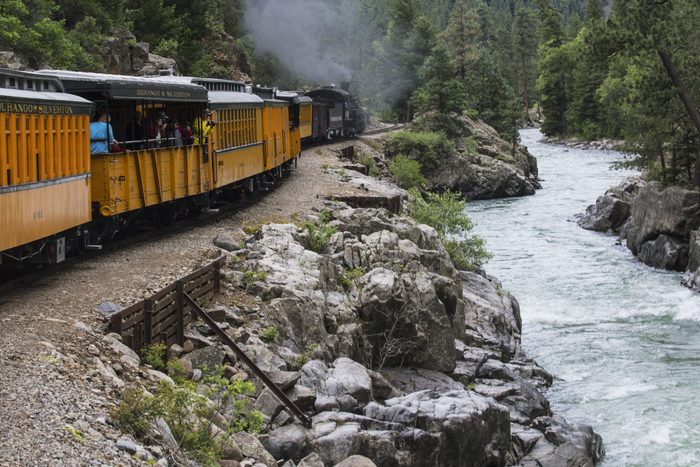 Durango and Silverton Narrow Gauge Railroad Steam Engine travels along Animas River, Colorado