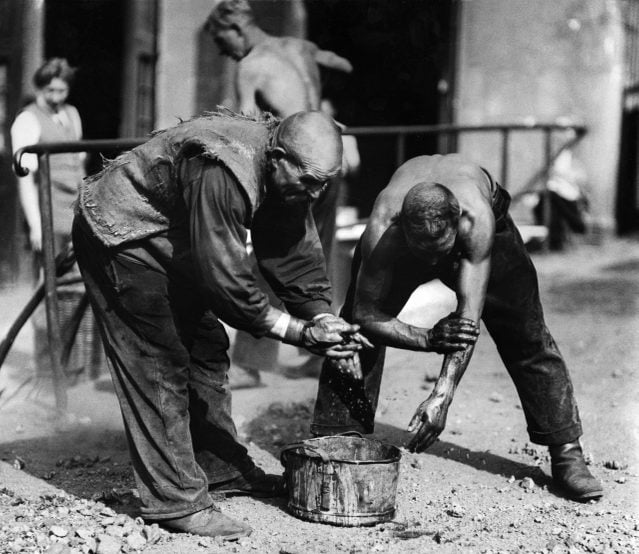 Workers at an engineering works washing themselves with water from a bucket after having finished their workday - 1930- Photographer: Seidenstuecker- Published by: 'Tempo' 04.04.1930Vintage property of ullstein bild