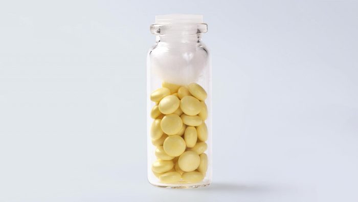 glass pill bottle with pills and a cotton ball inside