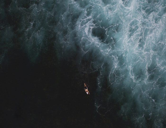 Aerial View of Surfer surfing waves