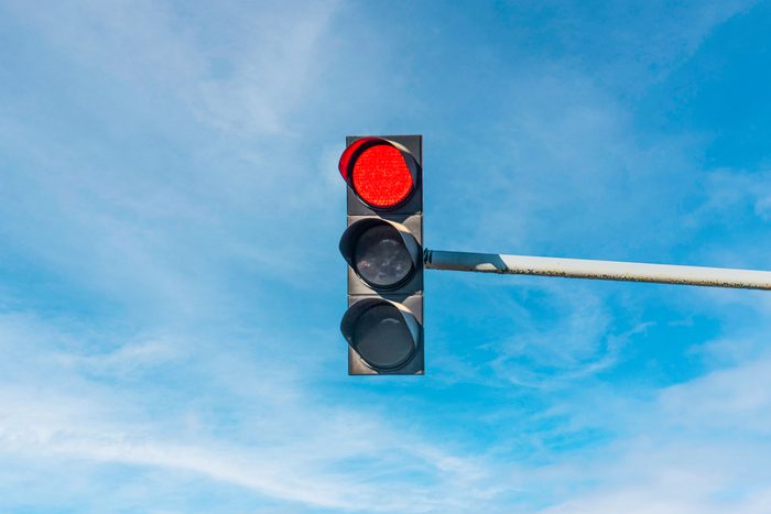 Modern Traffic Light With Red Light In Front Of Cloudless Sunny Blue Sky