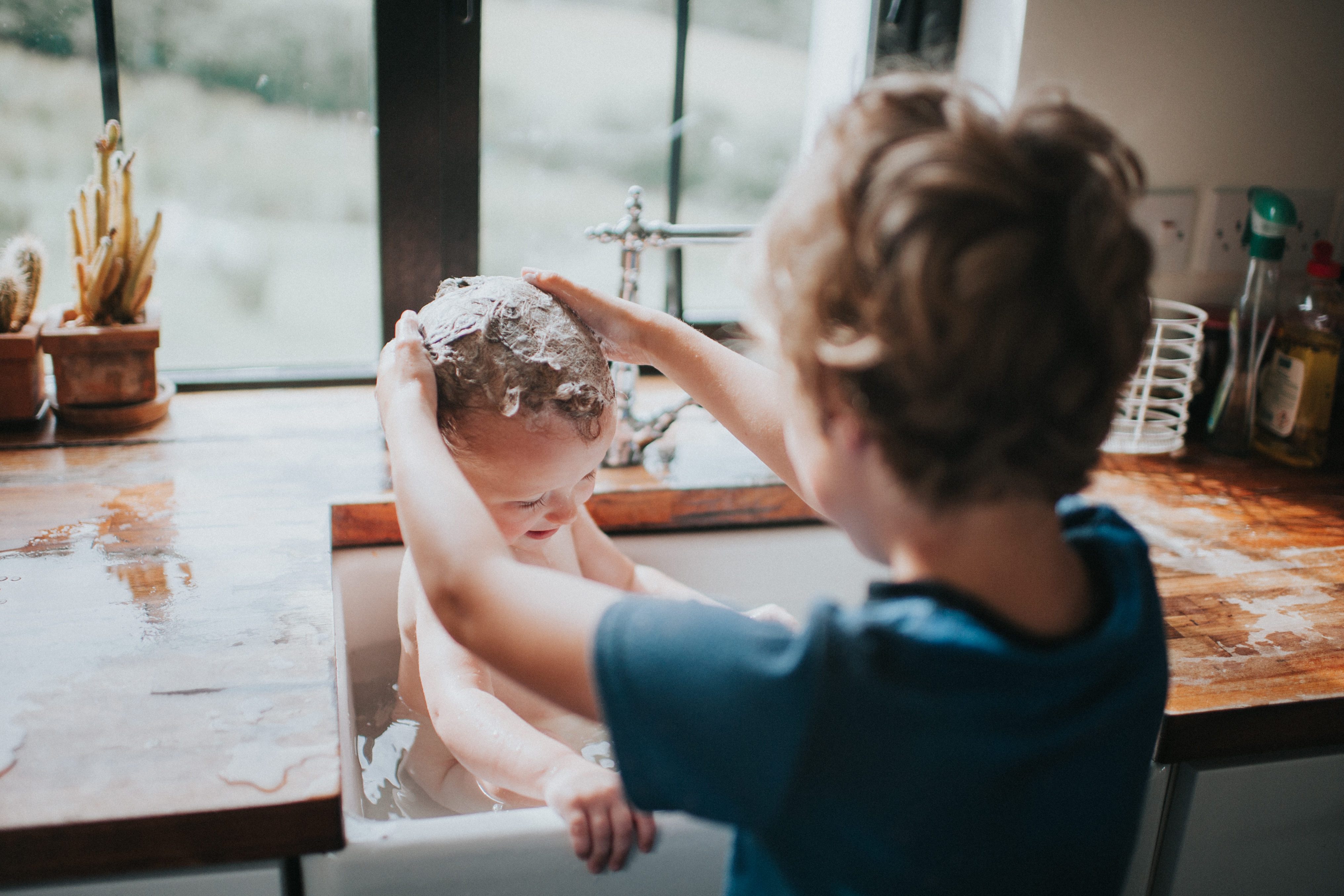 Big Brother washing sibling's hair