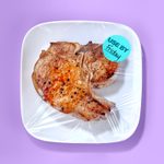 Cooked Meat on a white plate with saran wrap on purple background. on the saran wrap is a sticker that says use by friday