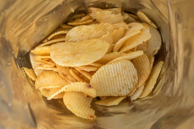 crisps potato chips in bag ready to eat - snack food background