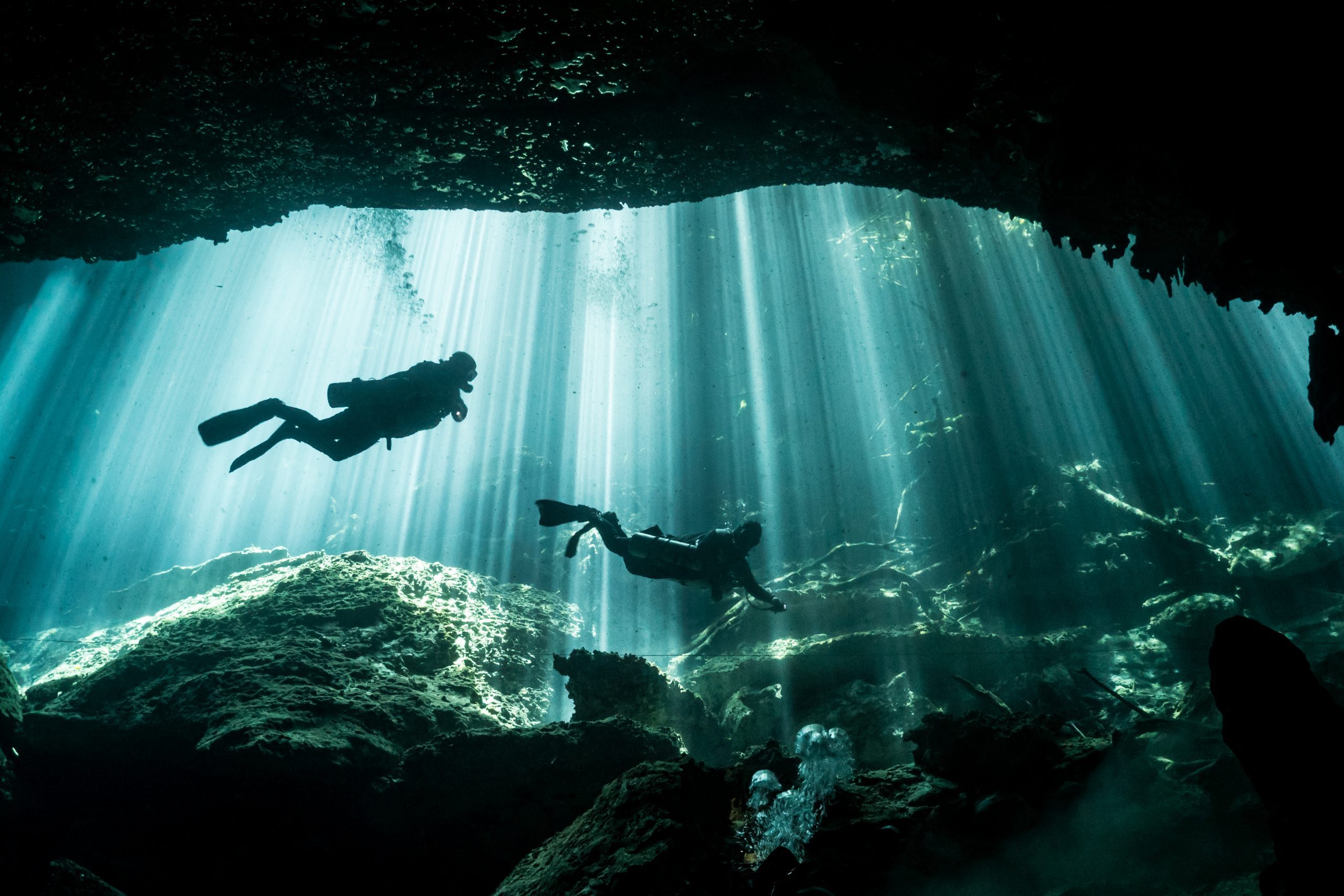 Scuba Divers and Light Rays in Eden Cenote