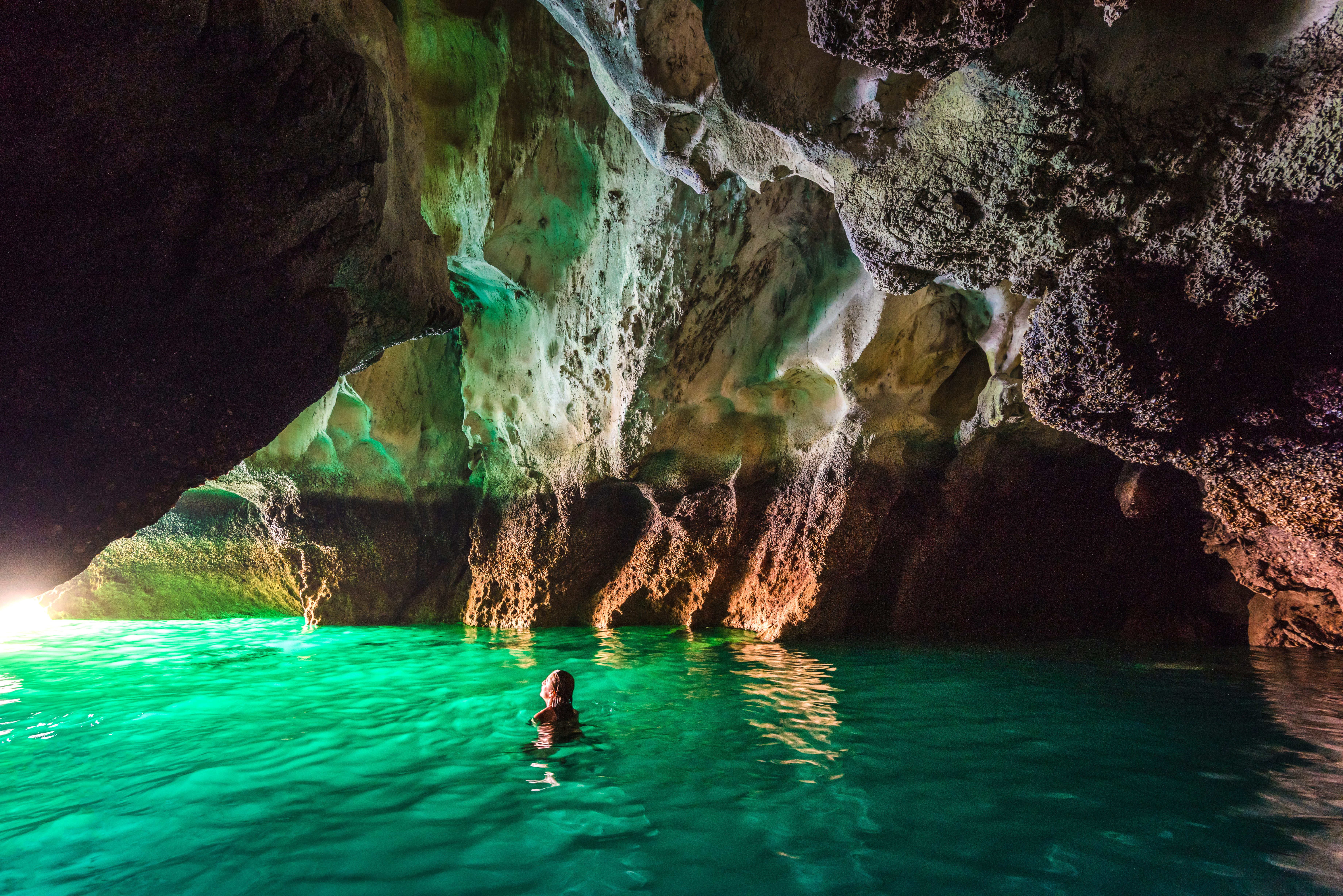 Woman swimming in Koh Mook's Emerald Cave, Thailand