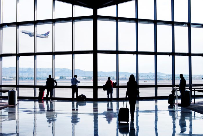 Silhouettes of passengers waiting at an airport
