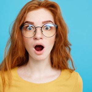 Portrait Of Shocked Woman Against Blue Background