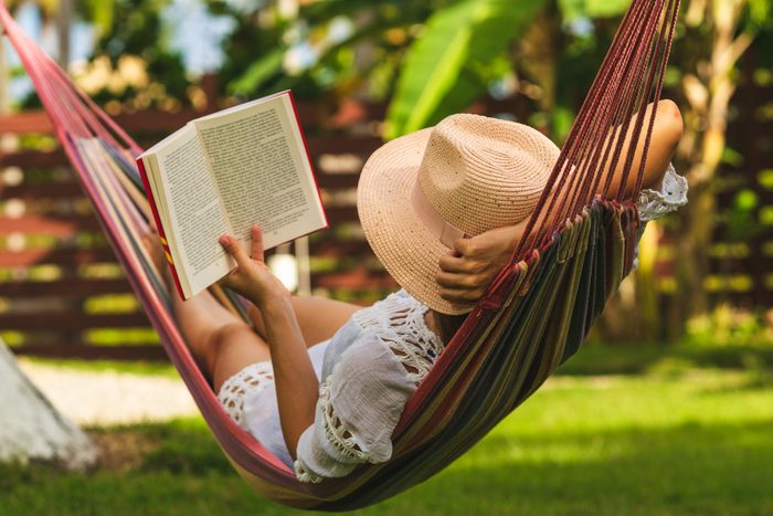 Attractive sexy woman reading book in hammock.
