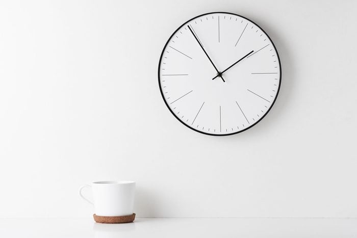 Close-Up Of Coffee Cup On Table Wall With Clock