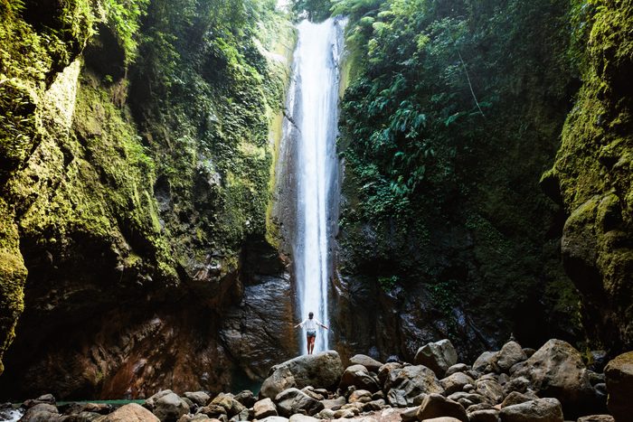 Woman under tall waterfall, Negros, Philippines